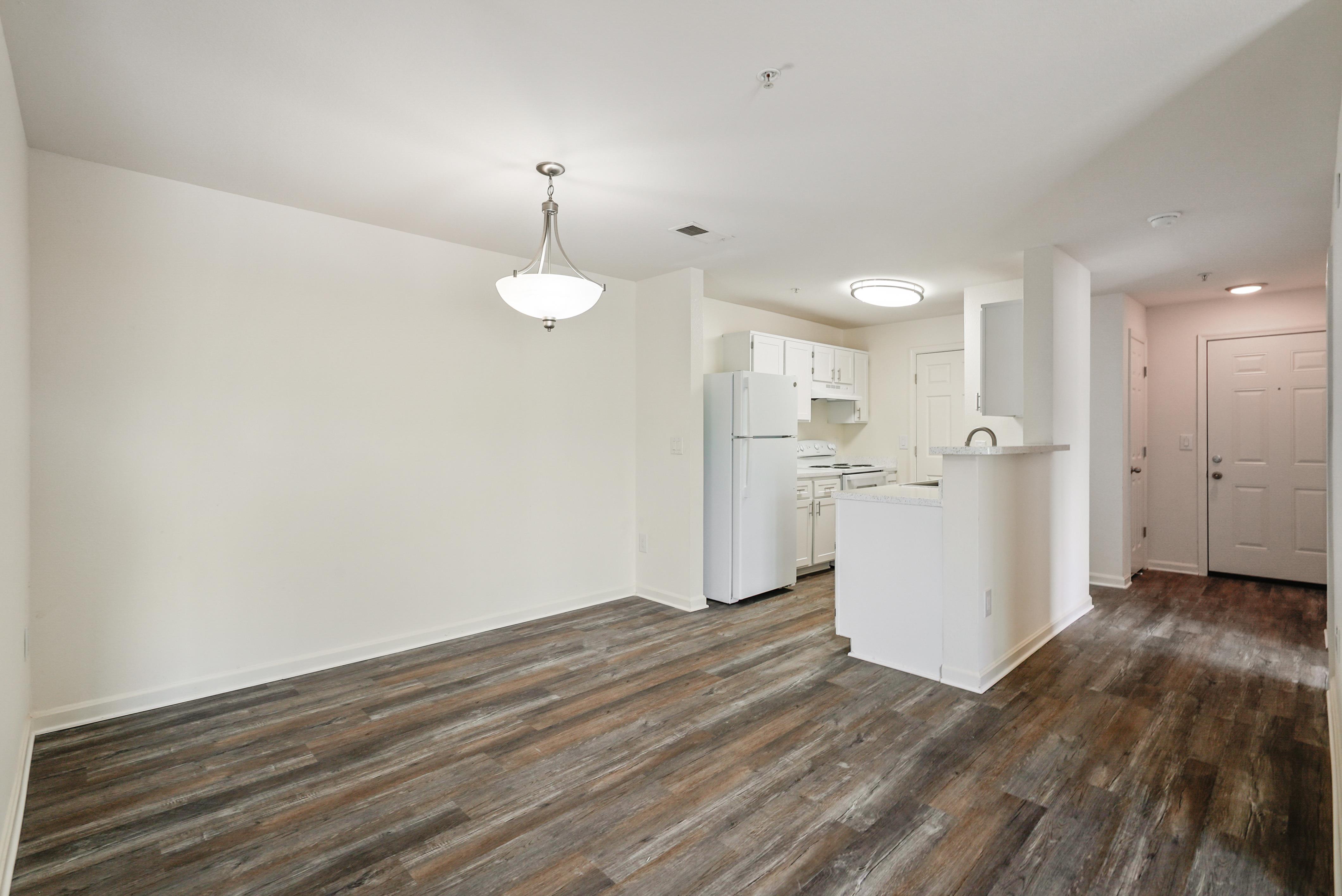 Open-concept dining and kitchen space, featuring recently updated flooring in select standard market apartment homes.